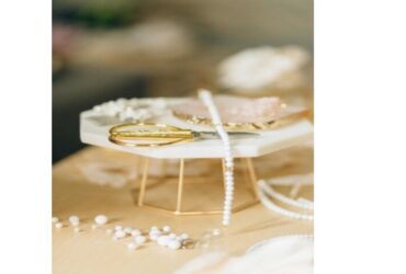 Nahaufnahme von weißen Perlen und goldenem Werkzeug auf hellem Tisch – Schmuckmaterial für handgefertigten Schmuck
